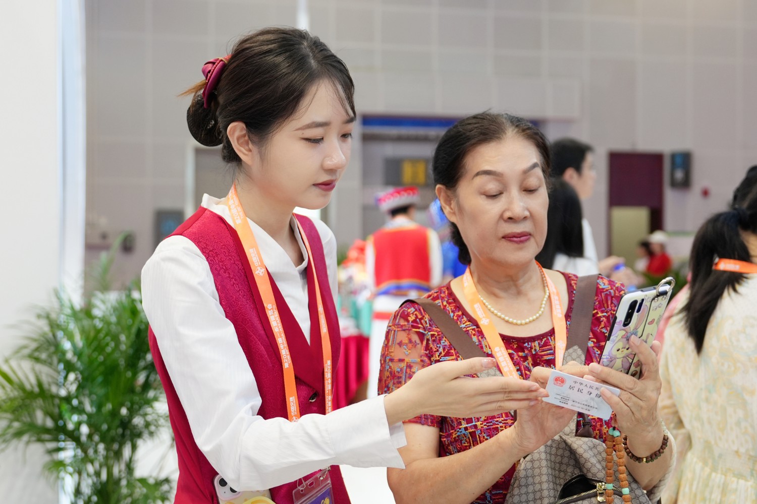 图为观展客户在展台工作人员指导下体验工行数字金融业务。（杨元福/摄）