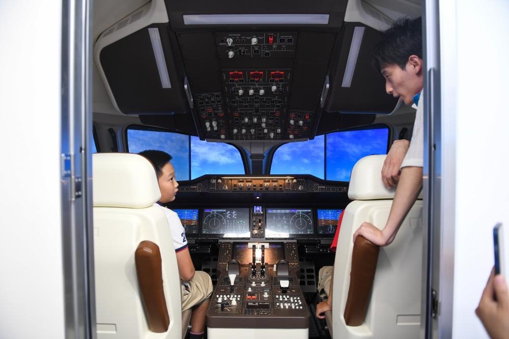 9月17日，在全国科普日北京主场活动展区，两名小朋友在体验C919模拟驾驶器。新华社记者鞠焕宗 摄