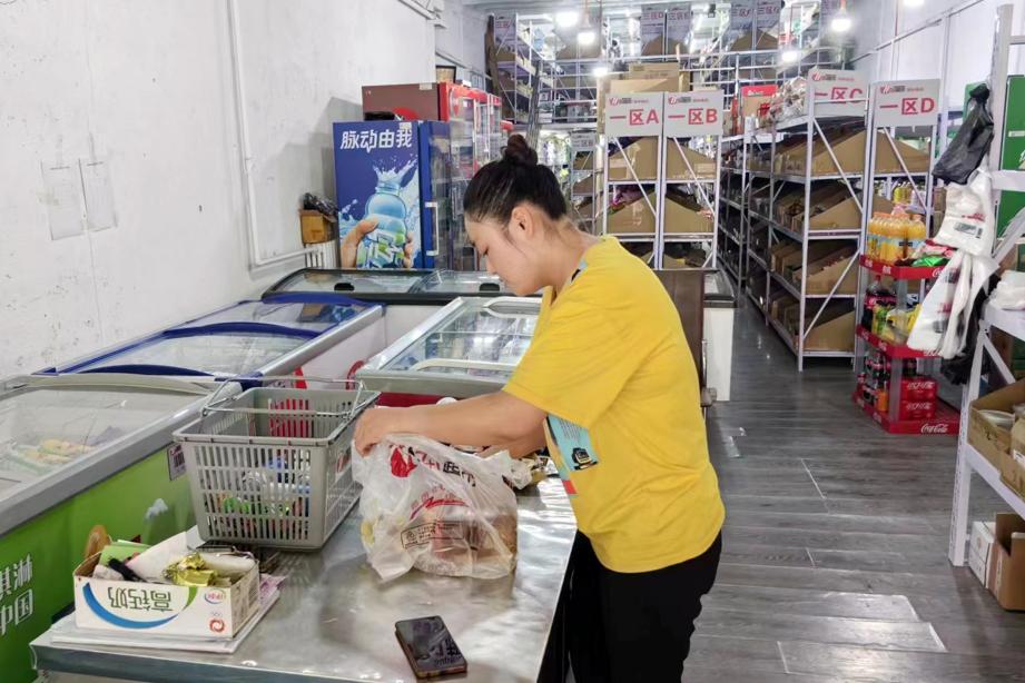"7 1"线上便利店店员正在将货物打包等待骑手上门