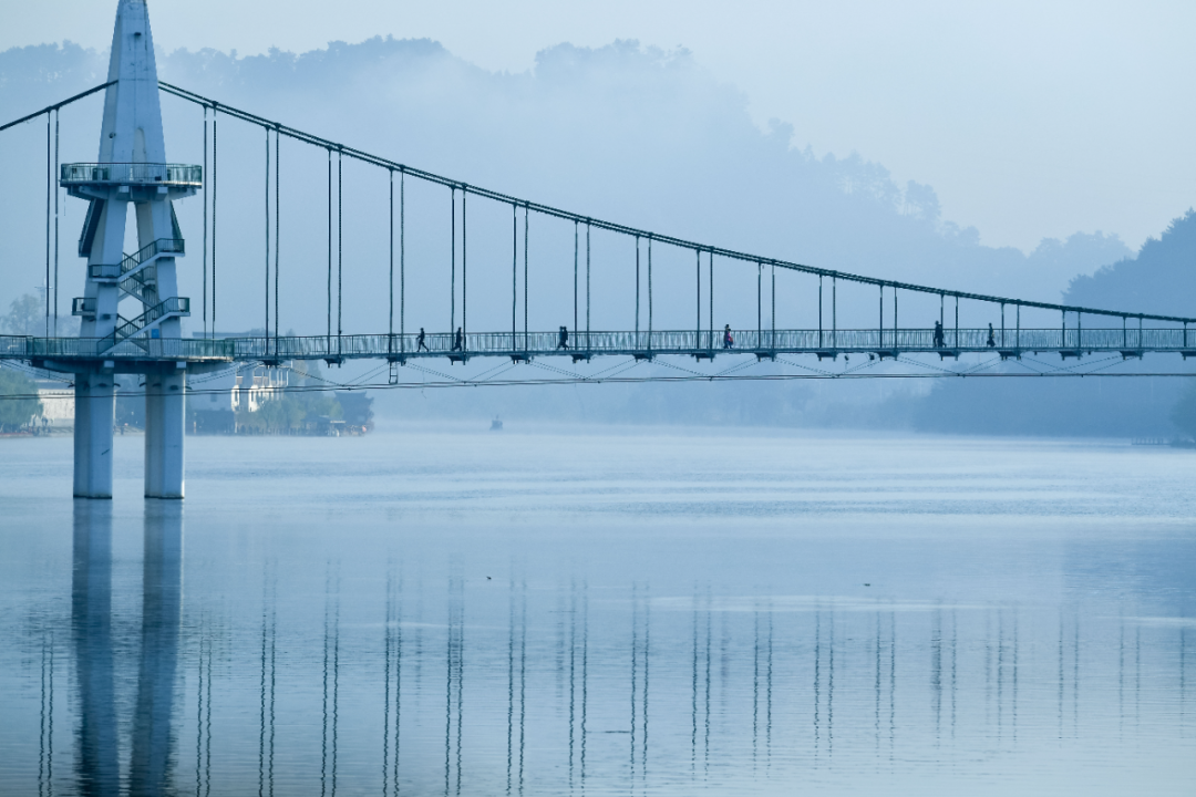 市民行走在黄山市屯溪区新安江的桥上.新华社记者 张端 摄
