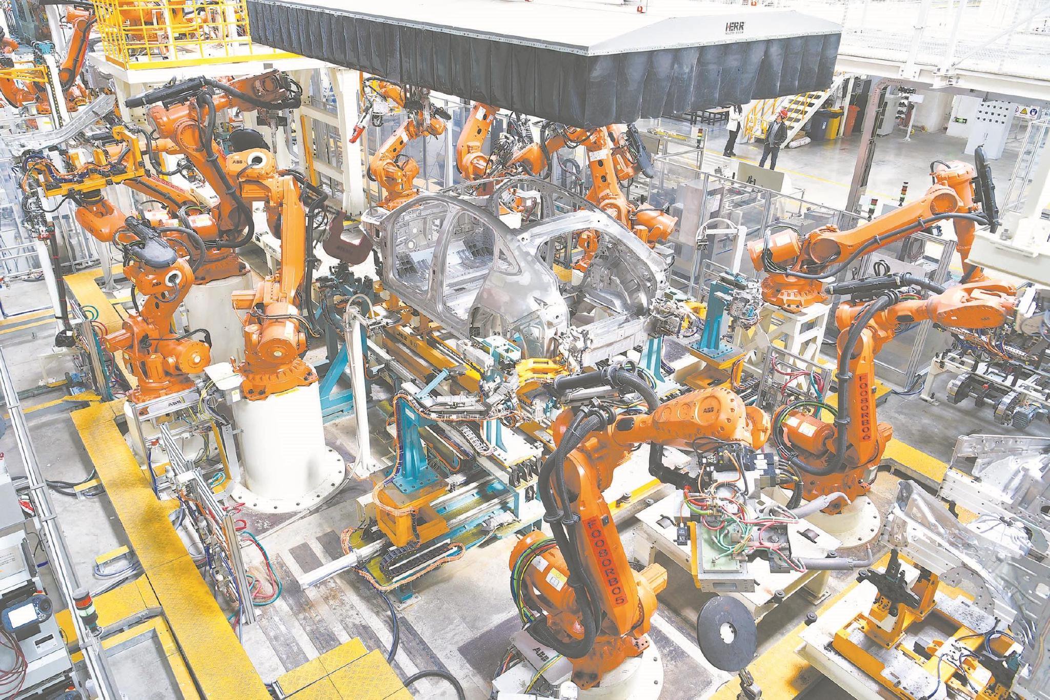 近日,在位于合肥经开区的蔚来汽车生产基地,智能机械臂在组装汽车.