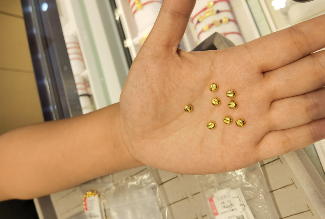 图为一门店销售人员展示金豆产品。新华社记者 马晓媛 摄