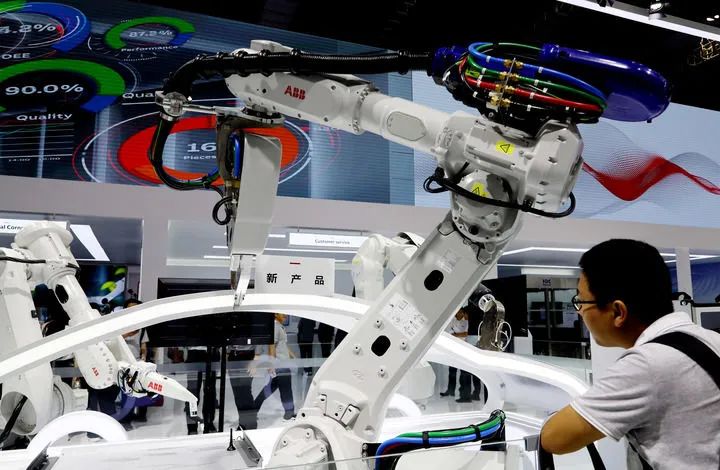 参观者在一组abb机器人静态展示展品前驻足观看