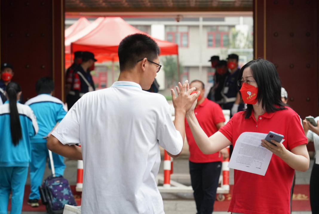 6月24日，在北京一零一中双榆树校区考点，考生进入考点前与老师击掌。新华社记者 任超 摄