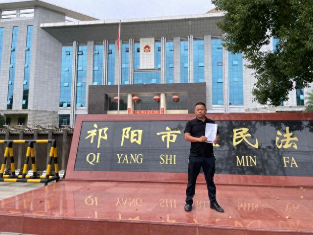 刘美志在祁阳市人民法院门口.受访者 供图
