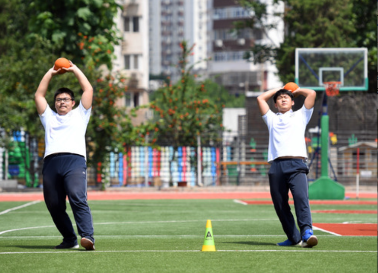 5月28日，北京市第十八中学初三年级的学生在体育课上投掷实心球。新华社记者 任超 摄