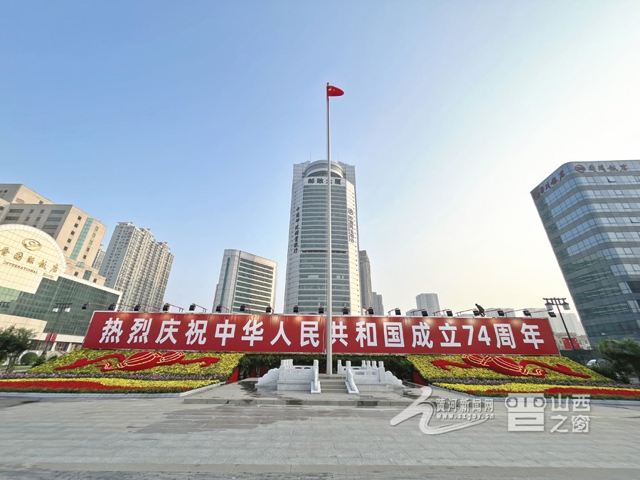 图为太原市五一广场,国旗在鲜花的簇拥下迎风飘扬.