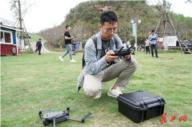 9月26日，全国重点新闻网记者们在灵山矿坑湖边飞起无人机记录灵山景色。长江网记者吕诗文 摄