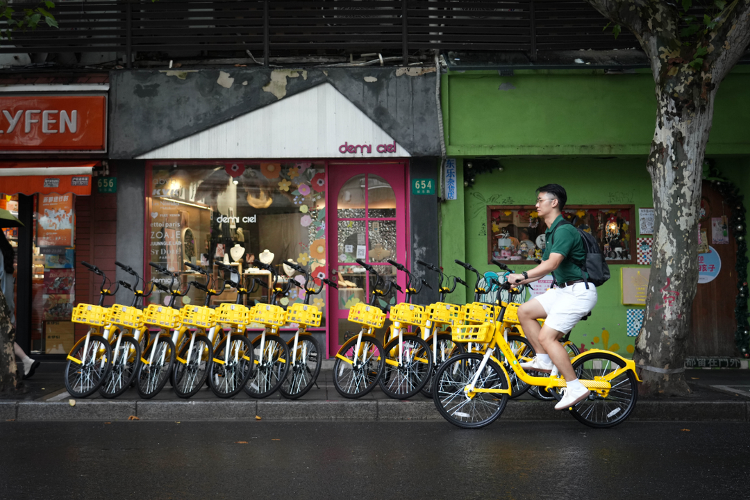用户骑行共享单车游览上海街区.