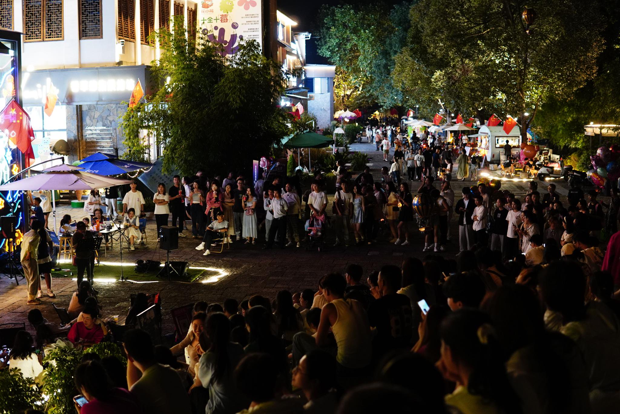 市民游客聚集在花溪十字街街头欣赏街头音乐会.(鲍贝贝 摄)