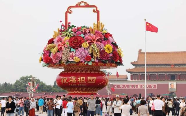 北京天安门广场,来自全国各地的游客们在"祝福祖国"巨型花篮下拍照