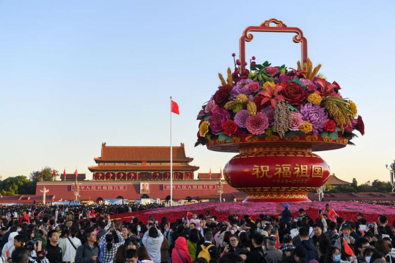 10月1日,在观看升旗仪式后,人们在北京天安门广场参观.