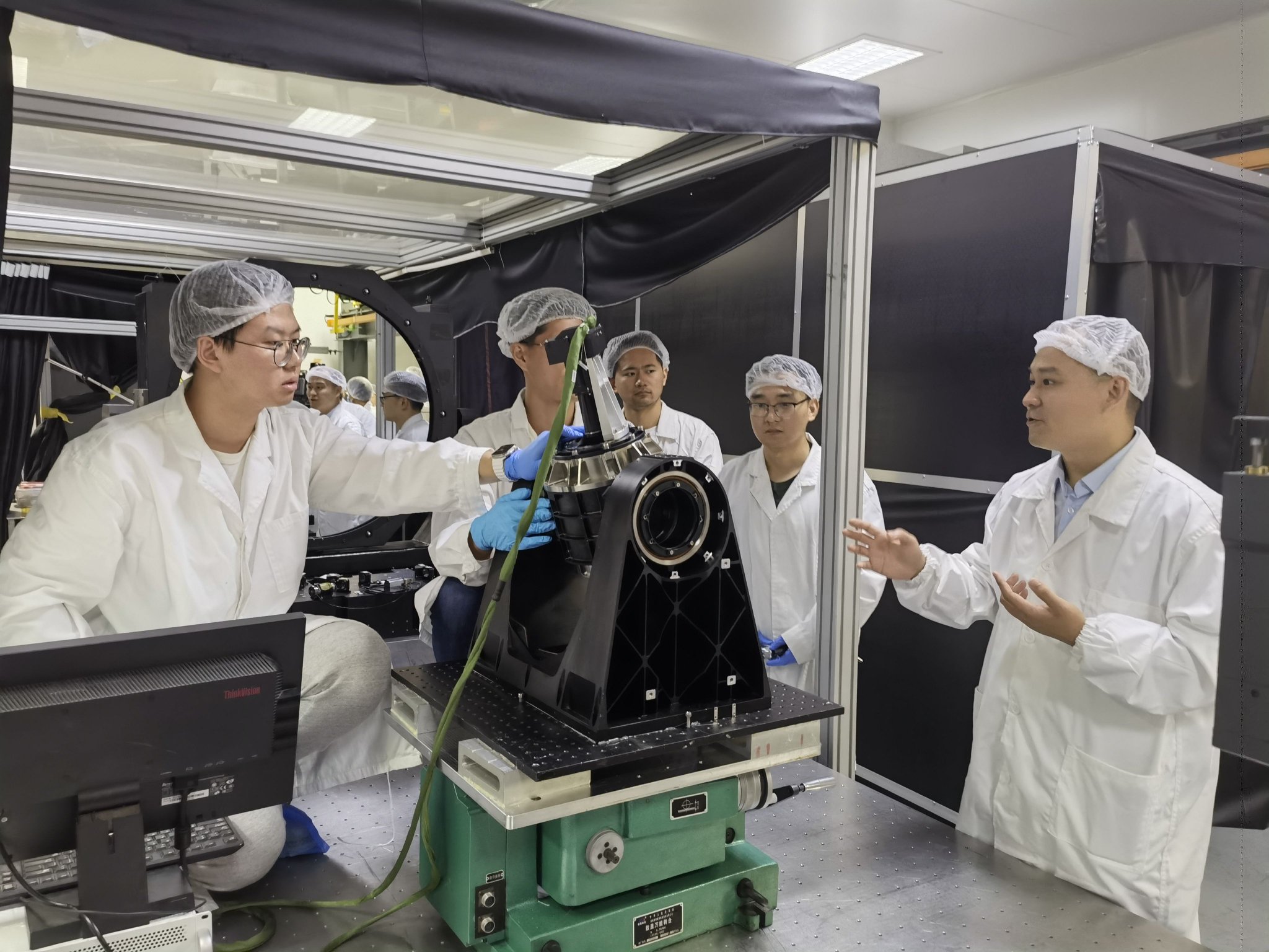 研究人员正在讨论量子卫星大负载高精度二维转台装调。