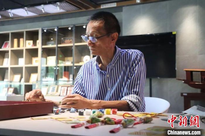 颜成荣在绘制南湖菱画 张艳 摄