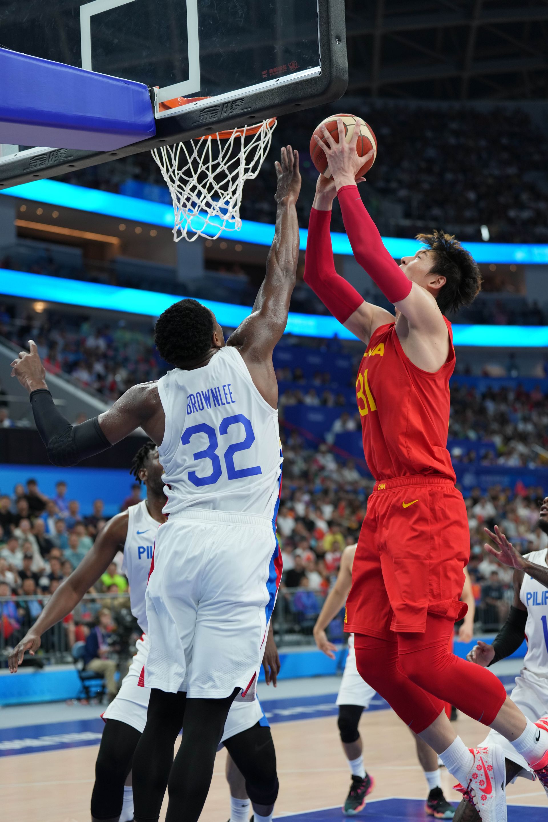 10月4日,中国男篮球员王哲林(红)在比赛中.本报记者 厉衍飞摄