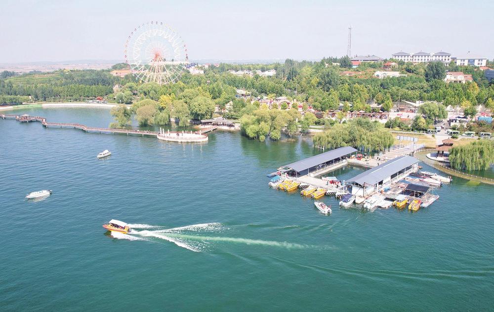 图为10月3日,游客在磁县溢泉湖风景区乘坐快艇游玩(无人机照片).