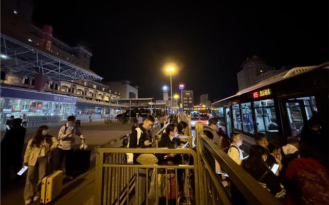 10月6日凌晨1点,旅客在北京西站北广场排队乘坐夜班公交.