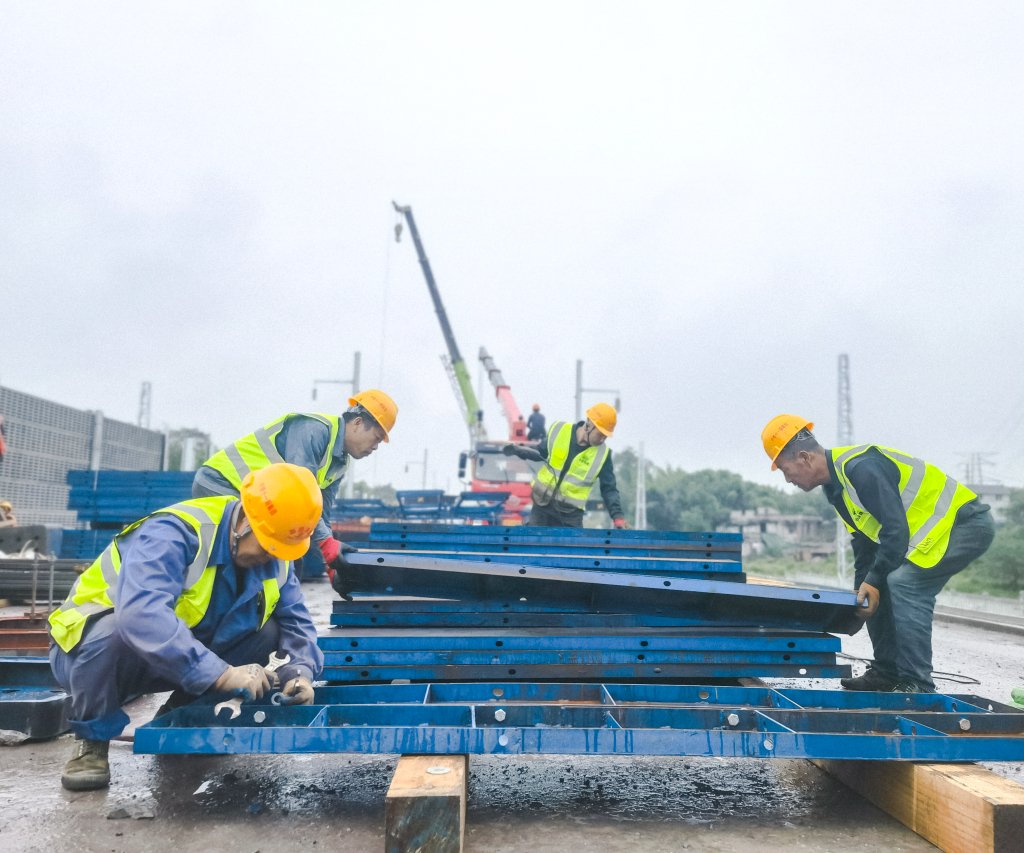 细雨中,工人打磨模板.通讯员 邓豪 摄