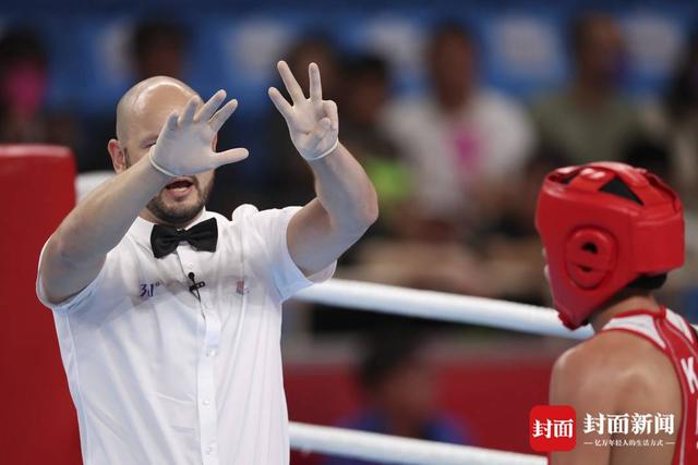 裁判对一位似乎无法坚持比赛的拳击手读秒.陈羽啸摄