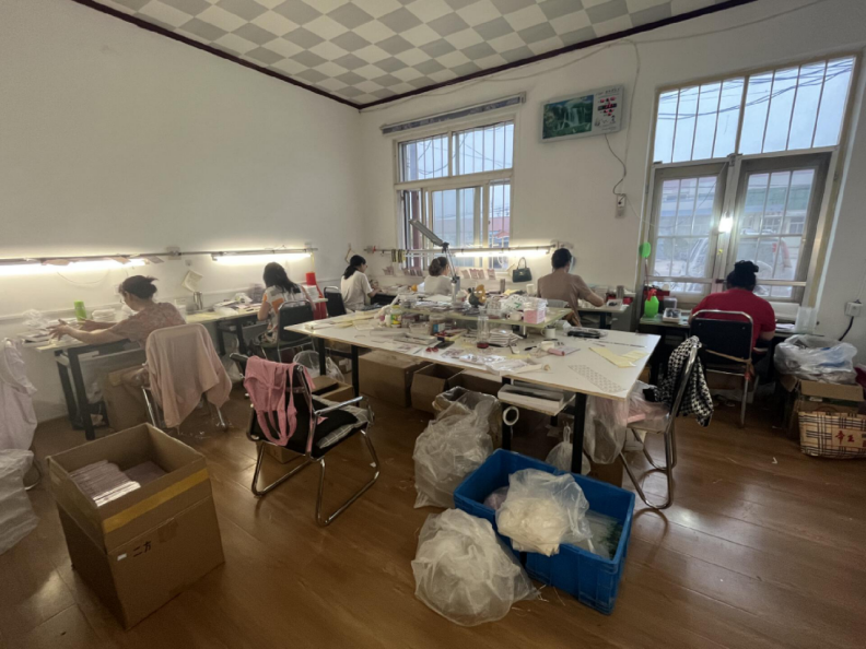 工厂大厅里,王磊的父亲,母亲正在打下手,母亲将女工们制作好的假睫毛