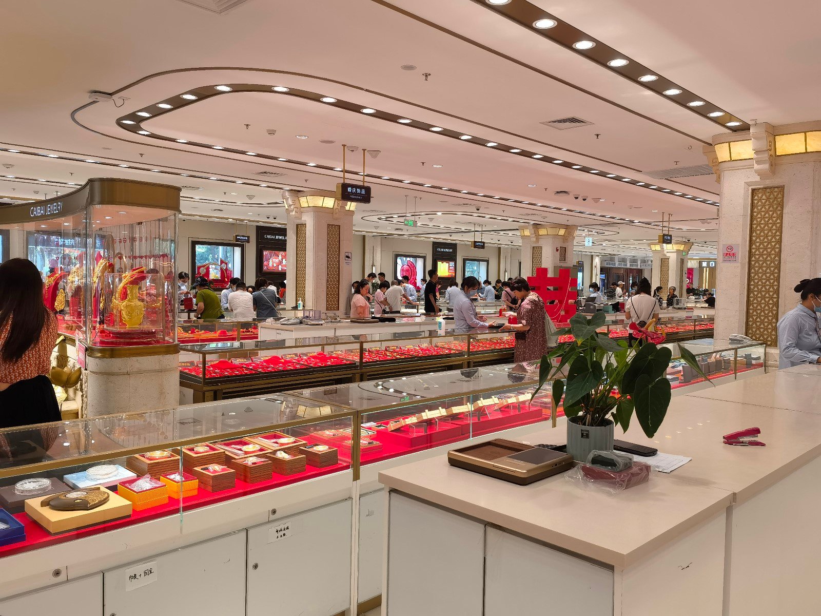 图为消费者在北京菜百首饰门店挑选黄金饰品。（中国商报记者 李沫楠/摄）