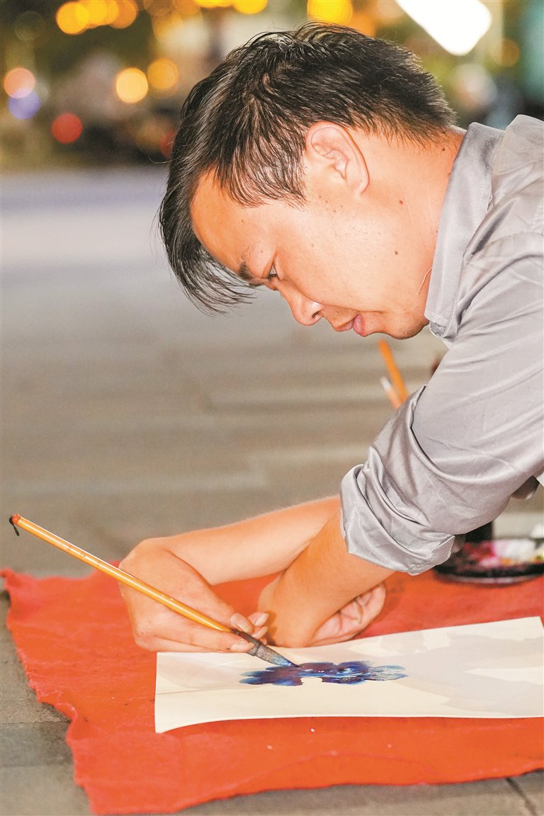 9月23日,龙岗区一街边,残障小伙苏进园在摆摊作画.