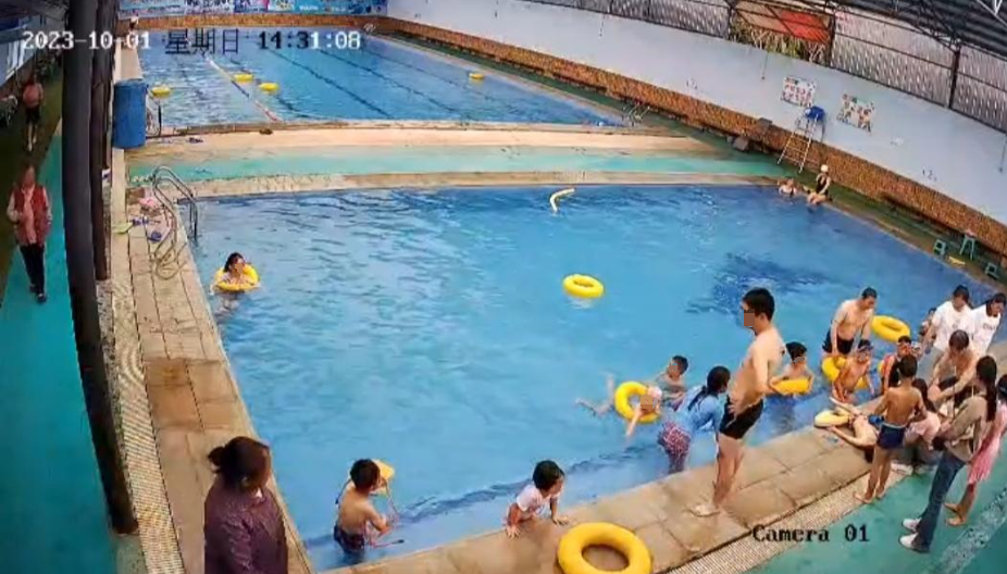 ▲众人在泳池边对男童展开抢救 监控视频截图