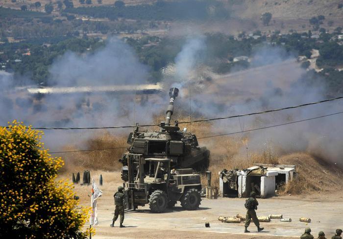 2021年8月4日，在以色列谢莫纳镇，一辆自行榴弹炮进入阵地。（新华社）