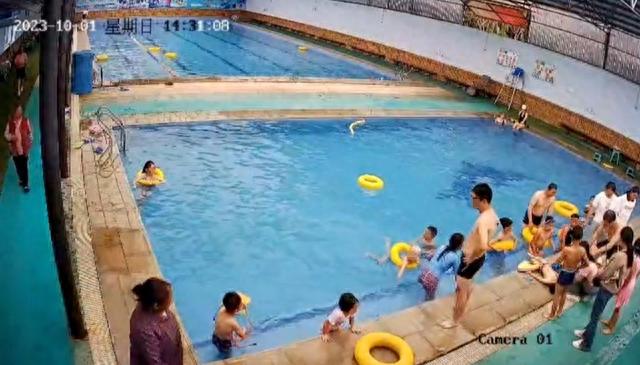 众人在泳池边对男童展开抢救 监控视频截图