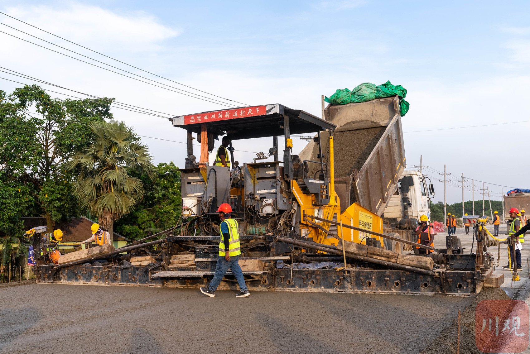 他的师傅,项目路面工程技术负责人彭开杰站在一旁,盯控着现场,间或