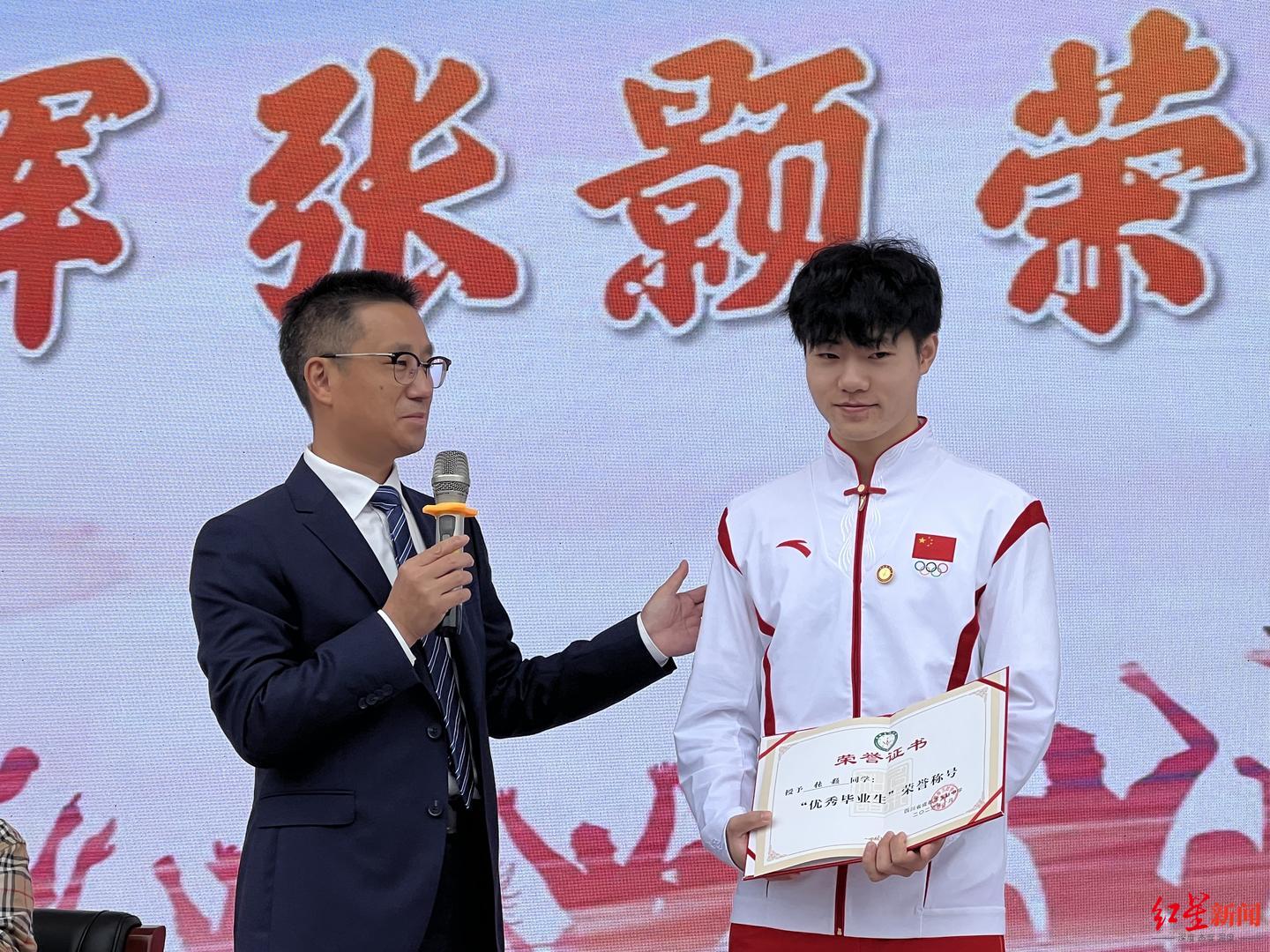 玉林中学校长谢发超为张颢颁发《优秀毕业生》证书