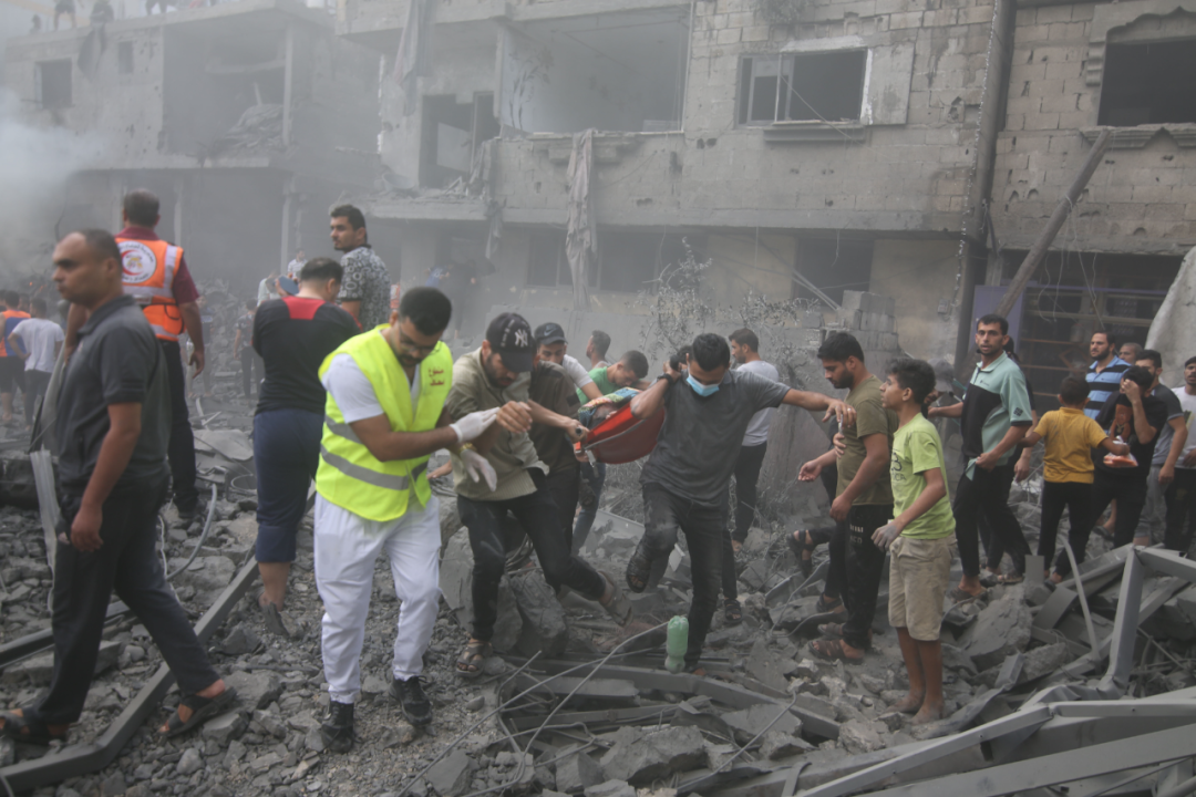 10月12日,在加沙地带南部城市拉法,人们在遭以色列空袭的受损建筑中