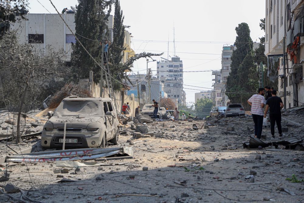 10月8日，巴勒斯坦人在加沙城查看以色列空袭后的街道。（图片来源：新华社）