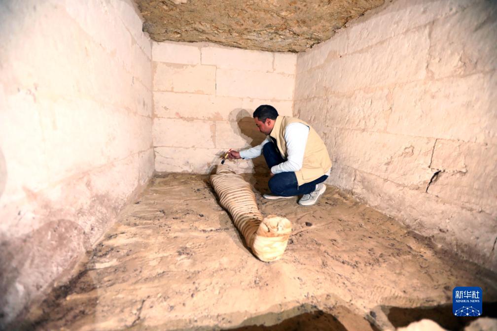 10月15日,在埃及明亚省考古现场,考古人员清理一座石凿墓中的木乃伊.