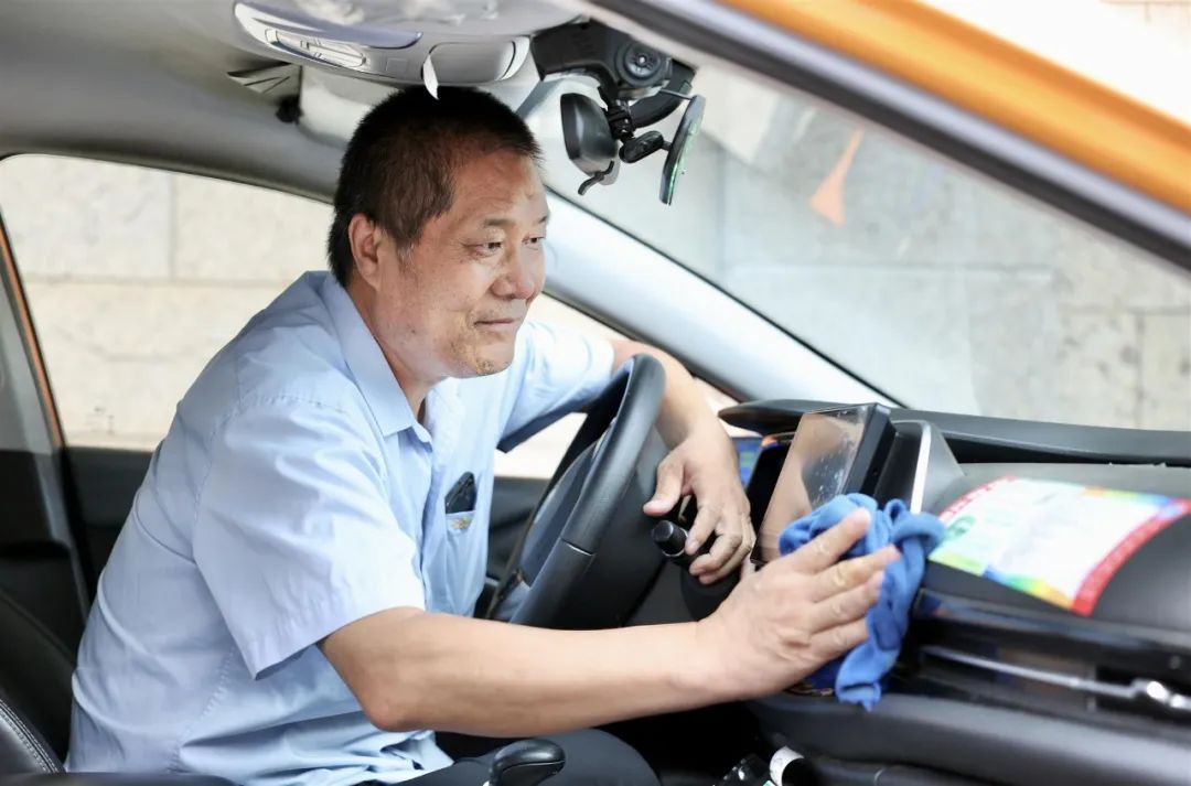 10月17日,"的哥"刘树臣在擦拭车厢内部.刘琪成 摄