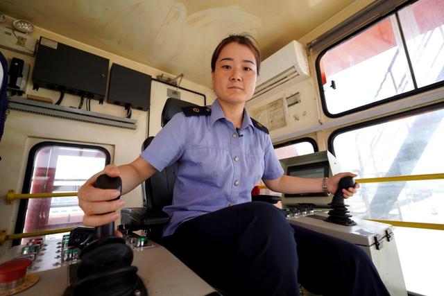 西安国际港第一位龙门吊女司机——袁佳静正在进行列车的货物装卸作业