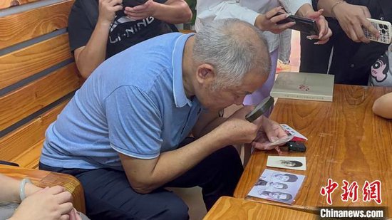 图为李道一在辨认照片里的人是不是"李大姐".陈沿佑 摄