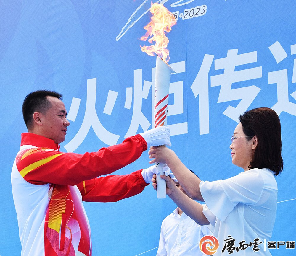 第一棒火炬手庄重接过火炬.记者 周隆富 摄