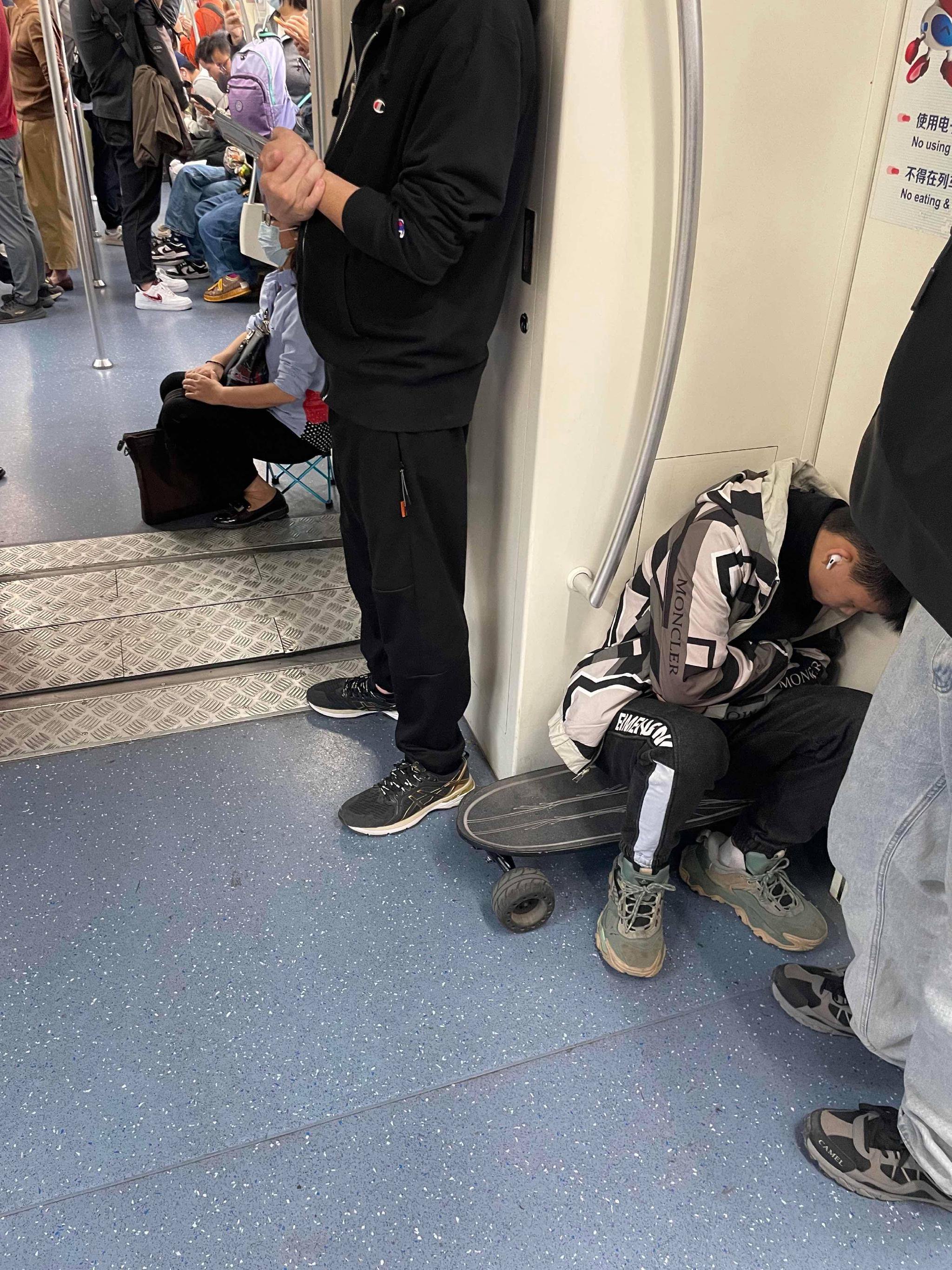 有人带着小板凳坐在车厢连接处;有人用滑板当板凳.