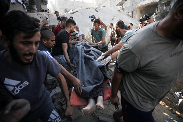 当地时间10月30日，以色列空袭加沙地带南部拉法后，一名巴勒斯坦妇女从倒塌的房屋中获救。图自视觉中国