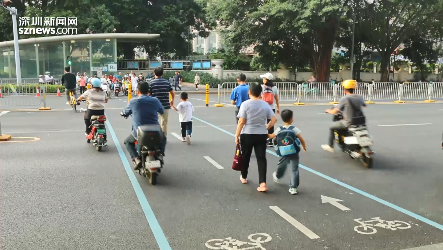 接孩子放学的家长通过非机动车道过马路