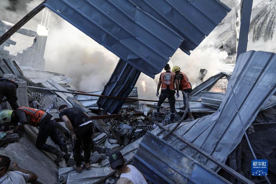 4日,在加沙城,救援人员在遭以色列袭击后的建筑废墟中实施救援.