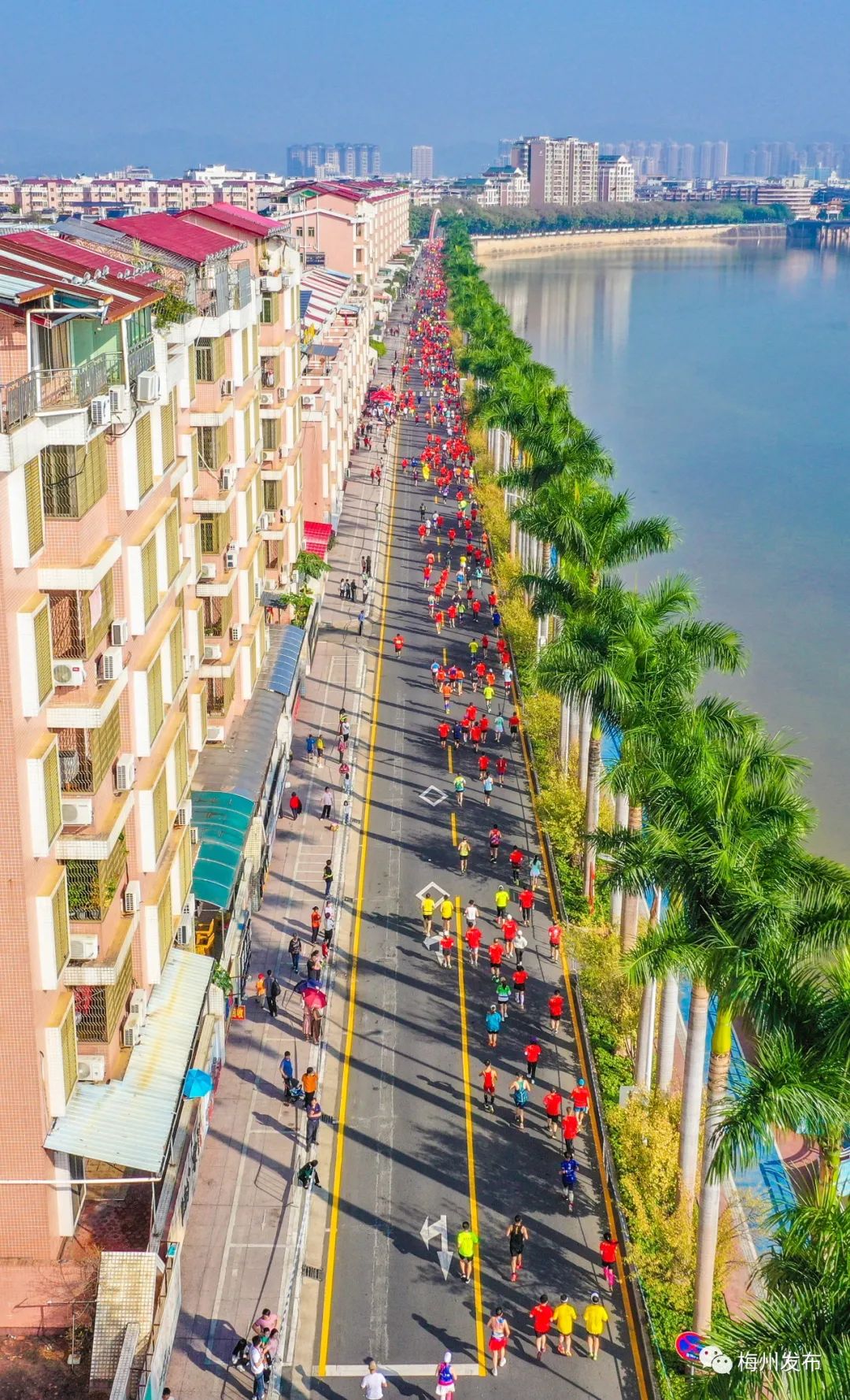 天蓝水清绿树成荫,选手们经过沿江路,形成一道美丽的风景线.