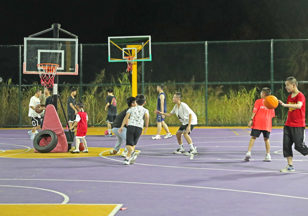 2023年7月5日,孩子们在南宁邕江边一个篮球场打球.新华社记者 周华 摄