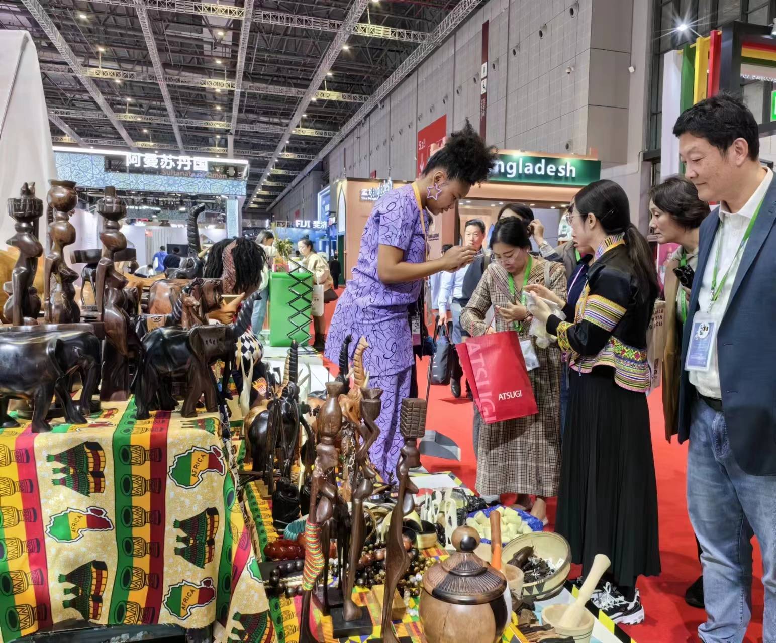 图为多哥共和国馆前,观展人在购买当地的农产品.文子玉 摄