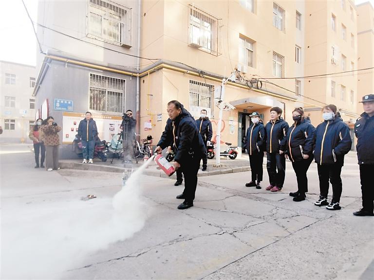 消防演练活动现场,物业公司人员学习正确使用灭火器.本报记者 张欢 摄