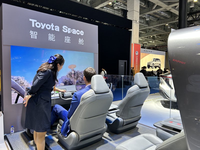 在丰田汽车展区,工作人员正在介绍toyota space智能座舱的功能.