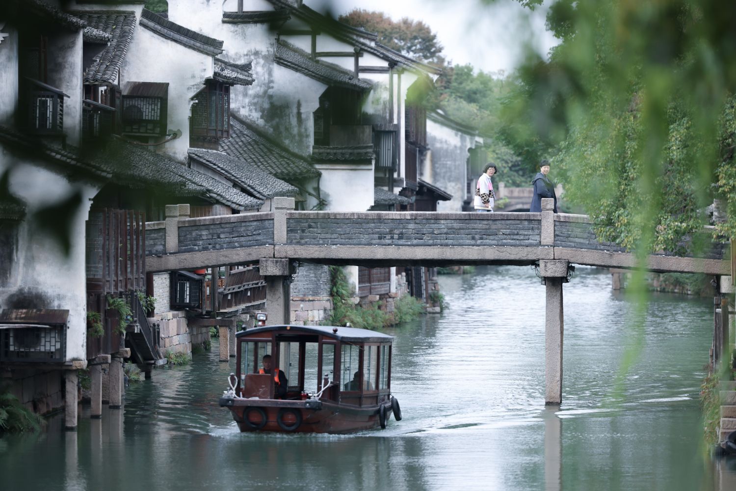 11月10日,游人在浙江乌镇西市河一座石桥上观景.新华社记者刘彬 摄