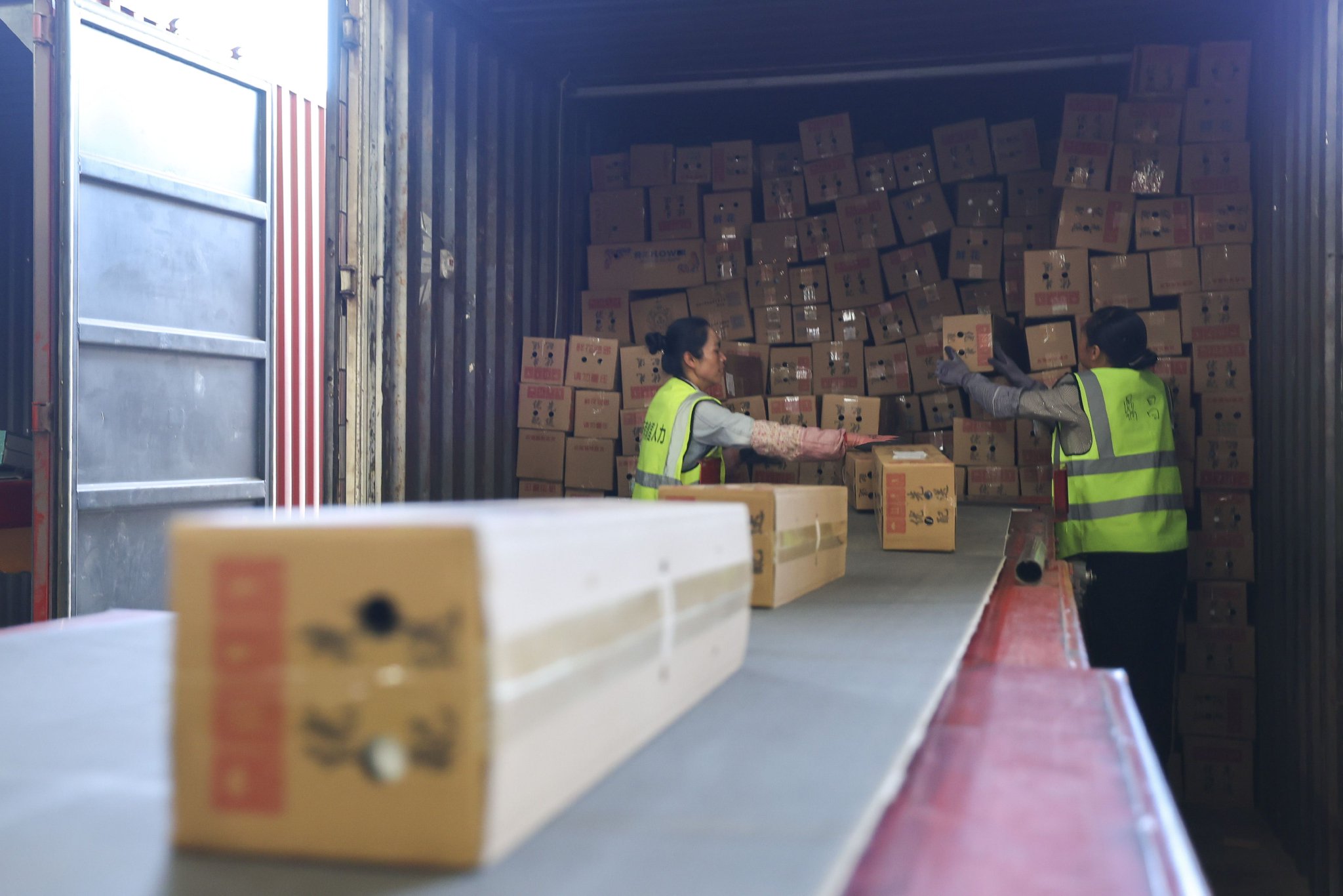 11月11日,顺丰昆明空港中转场的两名工作人员将包裹从待卸车辆搬运到