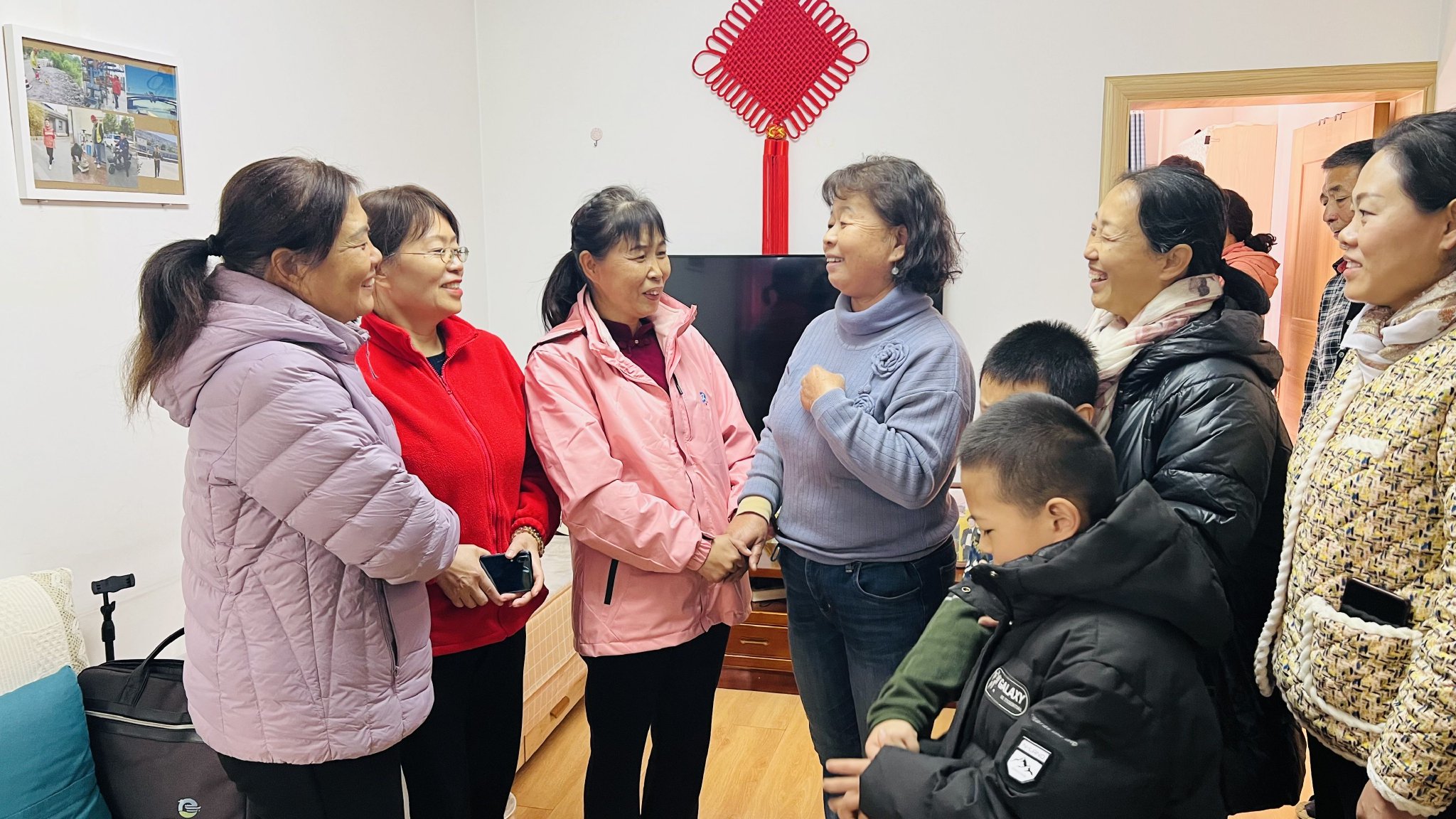 11月11日，街坊邻居聚在董彩英（左四）家，听她讲总书记来家里时的情景。 张洁 摄